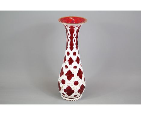 A Bohemian Cranberry and White Enamel Overlay Vase; the red vase with gilt highlights, approx 32 cms h.&nbsp;&nbsp;