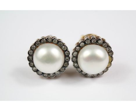 A Pair of Silver and Silver Gilt Button Pearl and Diamond Earrings; the button pearls 2 x 8.5 mm, surrounded by approx 36 pts