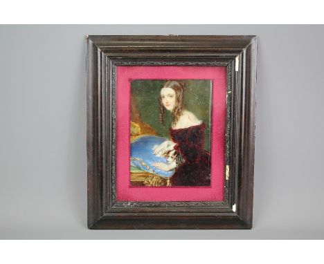 A Fine 19th Century Portrait Miniature of a Young Woman, she is depicted looking directly at the viewer wearing a red velvet 