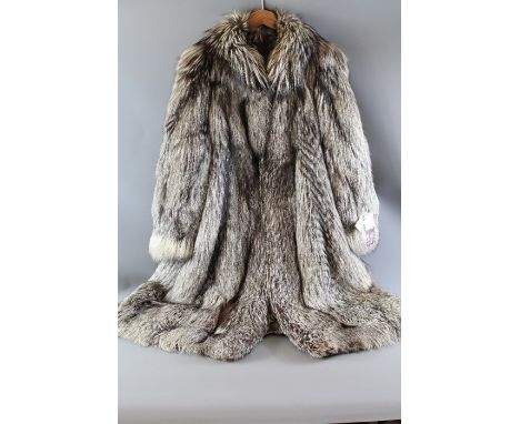A Full Length Silver Fox Fur Coat; the coat labels reading "SAGA FOX" and Superb Quality Ranched Fur Made in Italy, the other