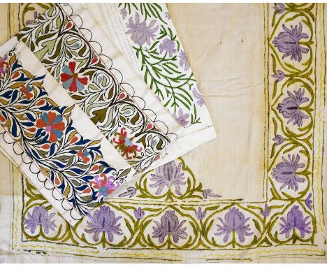 A silk embroidered cotton table cloth, embroidered with a frieze of flower stems in purple and green, another similar, anothe