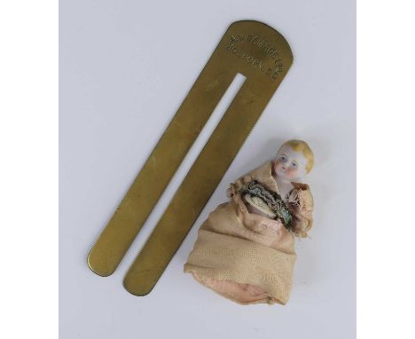 A brass button stick by A.W. Gamage Ltd of Holborn, London, 17cm; together with a miniature bisque doll wearing a silk dress,