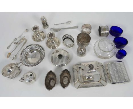 A collection of silver wares to include pocket cigarette case, table cruets, napkin rings, dwarf table candlestick etc, weigh