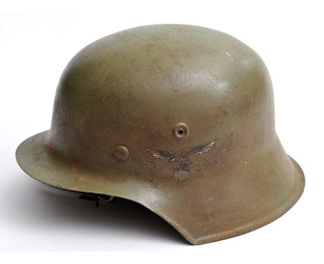 A Third Reich Luftwchutz steel helmet, painted apple green and with Luftwaffe and national decals, retaining Luftschutz liner