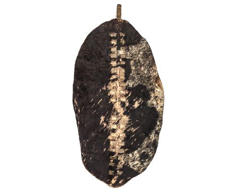 A large Zulu war shield, of dark brown and white hide, cut out and slotted centre panel, thick cord binding to top of stick, 