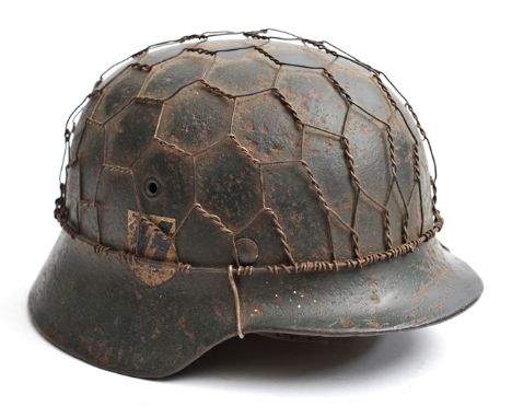 The skull of a Third Reich M40 single decal SS steel helmet,  deeply pitted, with added “Chicken wire” and leather lining, an