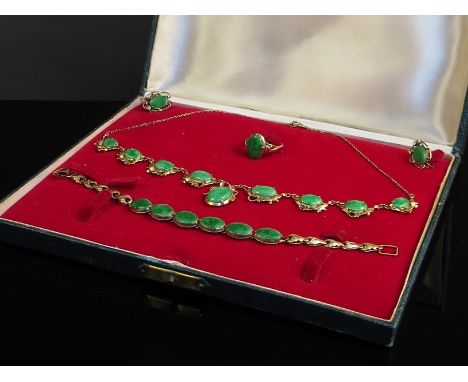 A gold and jade necklace, the eight cabochon jade panels on "bow" setting hung with oval jade droplets, with similar jade bra