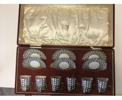 Cased HM Silver Royal Worcester coffee cup and saucer set.,in monochrome Fleur-De-Lis pattern, the cups set into HM silver ho