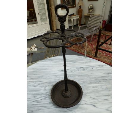 A CAST IRON STICK STAND, A RING HANDLE ABOVE SNAKES FORMING CIRCLES ABOVE THE CLUSTER COLUMN  AND DISHED CIRCULAR FOOT.   H 6