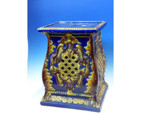 A BLUE GROUND POTTERY PLANTER STAND, THE SQUARE SECTIONED SIDES PIERCED WITH OCHRE GLAZED DIAMOND DIAPER WITHIN BROWN FOLIAGE