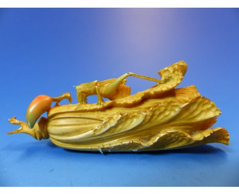 A JAPANESE TINTED IVORY CARVING OF A GRASS HOPPER ON A PAKCHOI WITH A CHILLI BY ITS STEM.  W 11cms. 