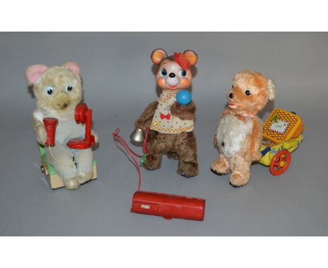 Three unboxed vintage battery operated tinplate toys including a Walking Bear pulling a tinplate cart which has a litho of an