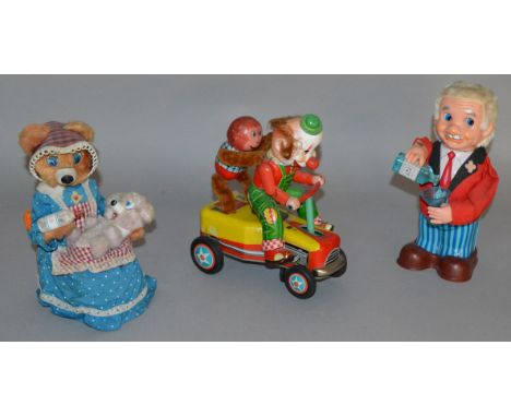 Three unboxed vintage Japanese battery operated tinplate toys including a Yonezawa (Japan)  Mother Bear figure, seated on a t