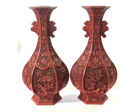 Large pair of lacquer cinnabar type vases of shaped design, carved with flowers