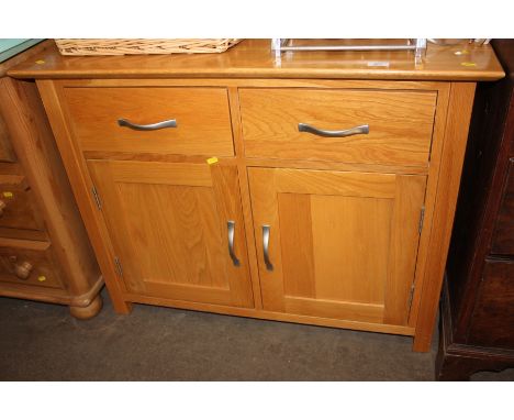 A modern light wood side board fitted two drawers and cupboards 