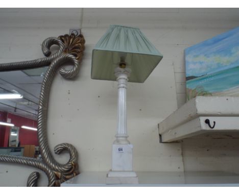 White marble table lamp with shade and unframed painting of a sea shore theme