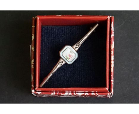 An Art Deco sterling silver bar brooch with enamel decoration in the style of Charles Horner. 