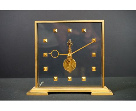 A modernist polished brass / gilt cased clock with jewel set movement. 