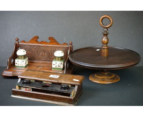 Two Early 20th Century oak inkstands, to include a carved oak example (with decorative back panel and original pair of cerami