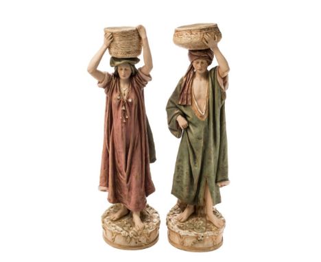 A pair of Royal Dux Bohemia (Edward Eichler) porcelain figures: each modelled standing bare footed and wearing loose smocks a