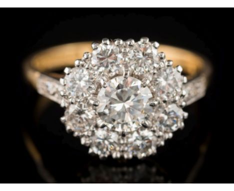 An 18ct gold and diamond mounted circular cluster ring: with central round brilliant-cut diamond 6.0mm  x 3.3mm estimated to 