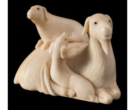 A Japanese ivory netsuke and one other: the first carved as a family of goats with ebony eyes, bears signature for Kaigyokusa