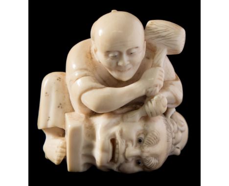 A Japanese carved ivory netsuke, signed Tomomasa koku [carved by Tomomasa]: of a squatting sculptor holding a large mallet an