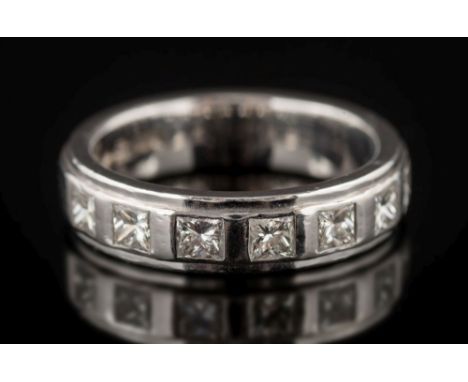 A modern 18ct white gold and princess-cut diamond seven-stone ring: in rub over setting, 8gms gross weight, ring size N. 