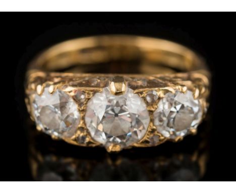 A late 19th century gold and diamond mounted three-stone ring: with graduated round old brilliant-cut diamonds approximately 