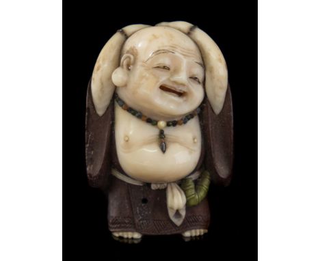 A Japanese carved and stained ivory and boxwood netsuke, signed Meikei: of Hotei with his hands held over his head, signed on