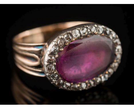 An antique gold, ruby and diamond oval cluster ring: with central oval ruby 13.4mm long x 9.0mm wide, in a foil-backed settin
