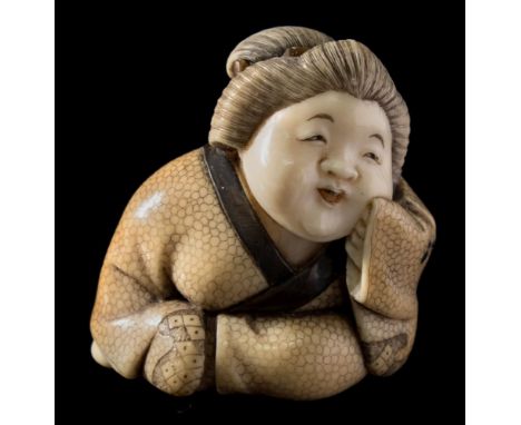 A Japanese carved, stained and inlaid ivory netsuke, signed Hosei: of a seated smiling woman, probably Okame, inlaid with hor