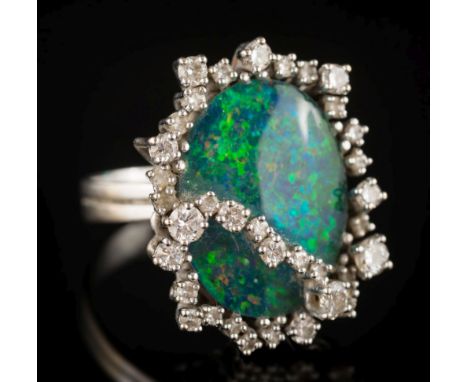 A black opal doublet and diamond oval cluster ring: the oval black opal approximately 19.5mm long, within a surround of gradu