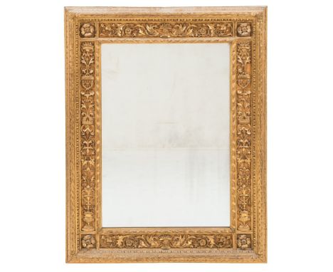 A late 19th Century carved giltwood rectangular wall mirror:, the plate within a spiral ribbon slip, surround with paterae, c