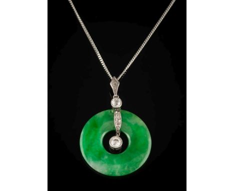 A jade disc and diamond pendant: the jade disc 26mm diameter with two round diamonds and smaller rose diamonds on an 18ct whi