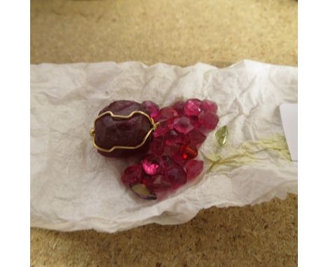 A small group of small cut rubies and others, along with a larger uncut ruby with a yellow metal wire surround