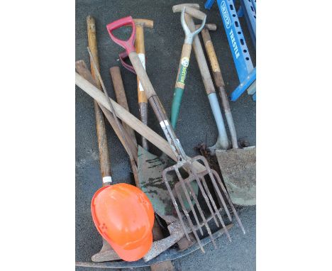 Collection of tools for groundwork including pickaxes, spades, shovels, forks, etc and safety helmet 