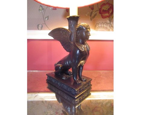 Pair of Regency style patinated bronzed metal table lamps, as winged seated sphinx on rectangular floral cast bases with plea