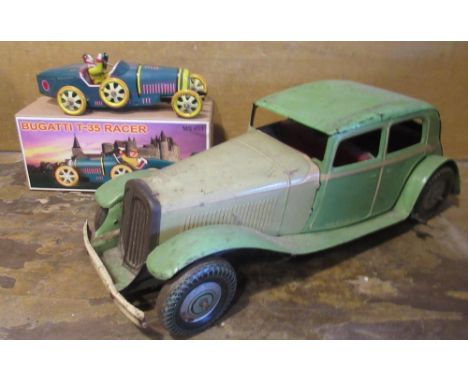 C20th English clockwork tinplate model of a saloon car printed "Made in GT Britain," and a modern clockwork tin plate model o