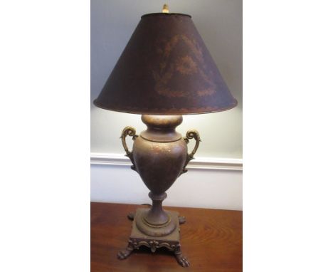 Regency style toleware decorated table lamp, urn shaped body with two scroll handles, on square base with four bold paw feet,