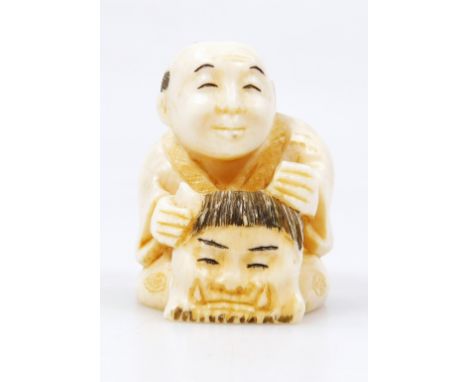 A Japanese Taisho period netsuke, formed as a figure in flowing robes holding mask, two character mark beneath, 4cm high.