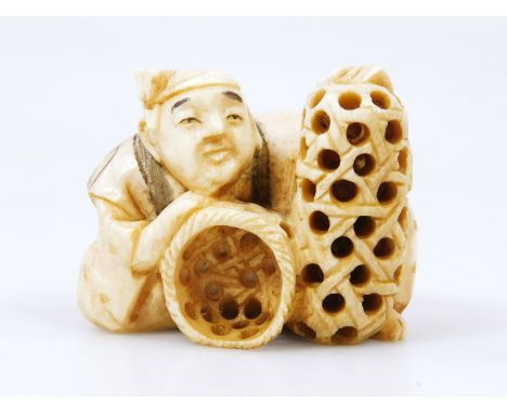 A Japanese Taisho period netsuke, formed as a gentleman in flowing robes, aside baskets, two character mark beneath, 4cm high