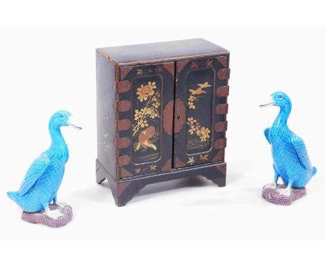 A pair of Chinese pottery figures of standing ducks, in blue on a shaped purple ground, impressed numbers beneath 072 and T80