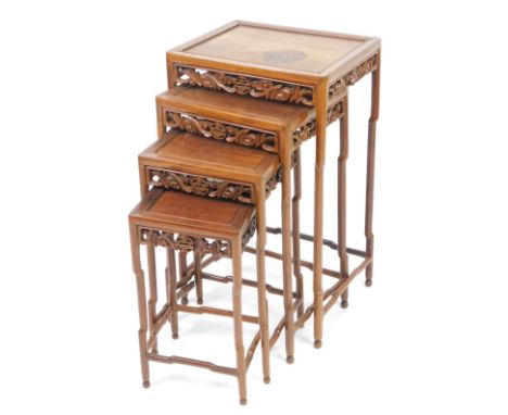 A nest of four Chinese carved wooden tables, possibly jumu wood, each of rectangular rounded outline with pierced rectangular