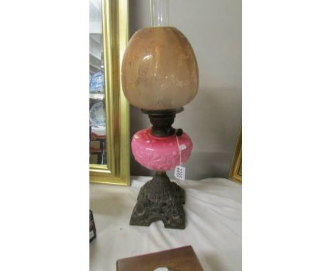 A 19th century oil lamp with pink glass font on a cast iron base and with original acid etched shade. (Collect only) ****Cond