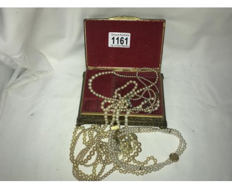 A jewellery box containing pearl necklaces