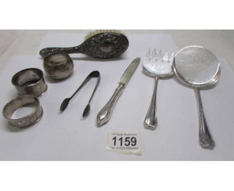 Eight items of silver including napkin rings, flatware, silver backed hair brush etc.,