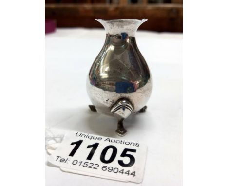 A silver three legged jug.