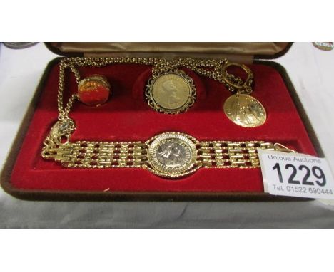 A cased coin set including pendant, bracelet, ring and key ring.