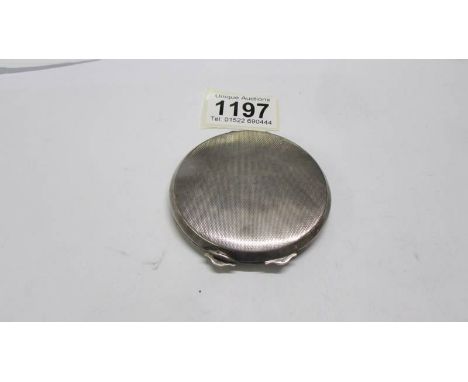 A silver powder compact.